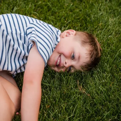 kid-laying-on-green-grass